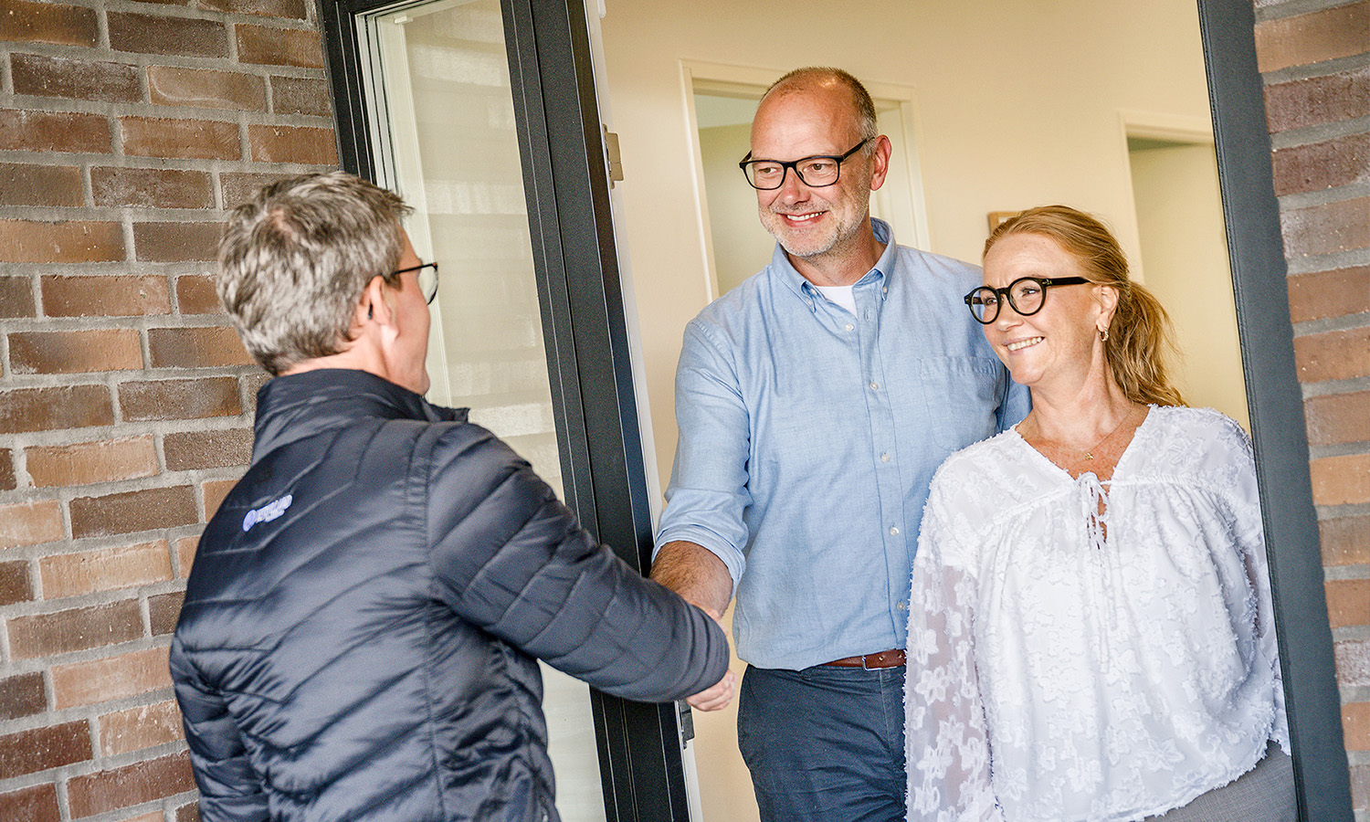 Assurandør ved spisebord sammen med yngre par